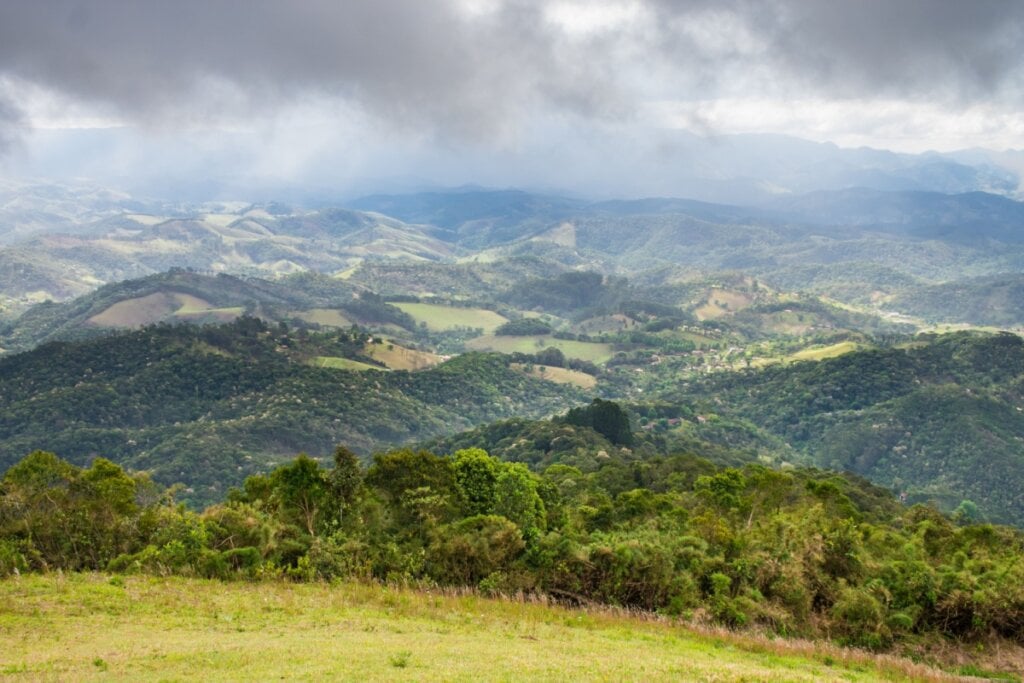 Vista das montanhas da Mantiqueira com montanhas verdes e céu com nuvens brancas 